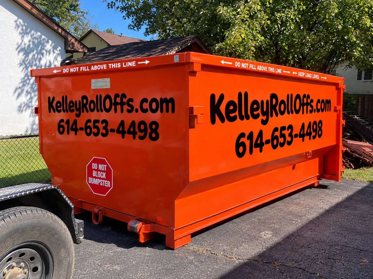 Kelley Roll Offs orange dumpster in a residential driveway