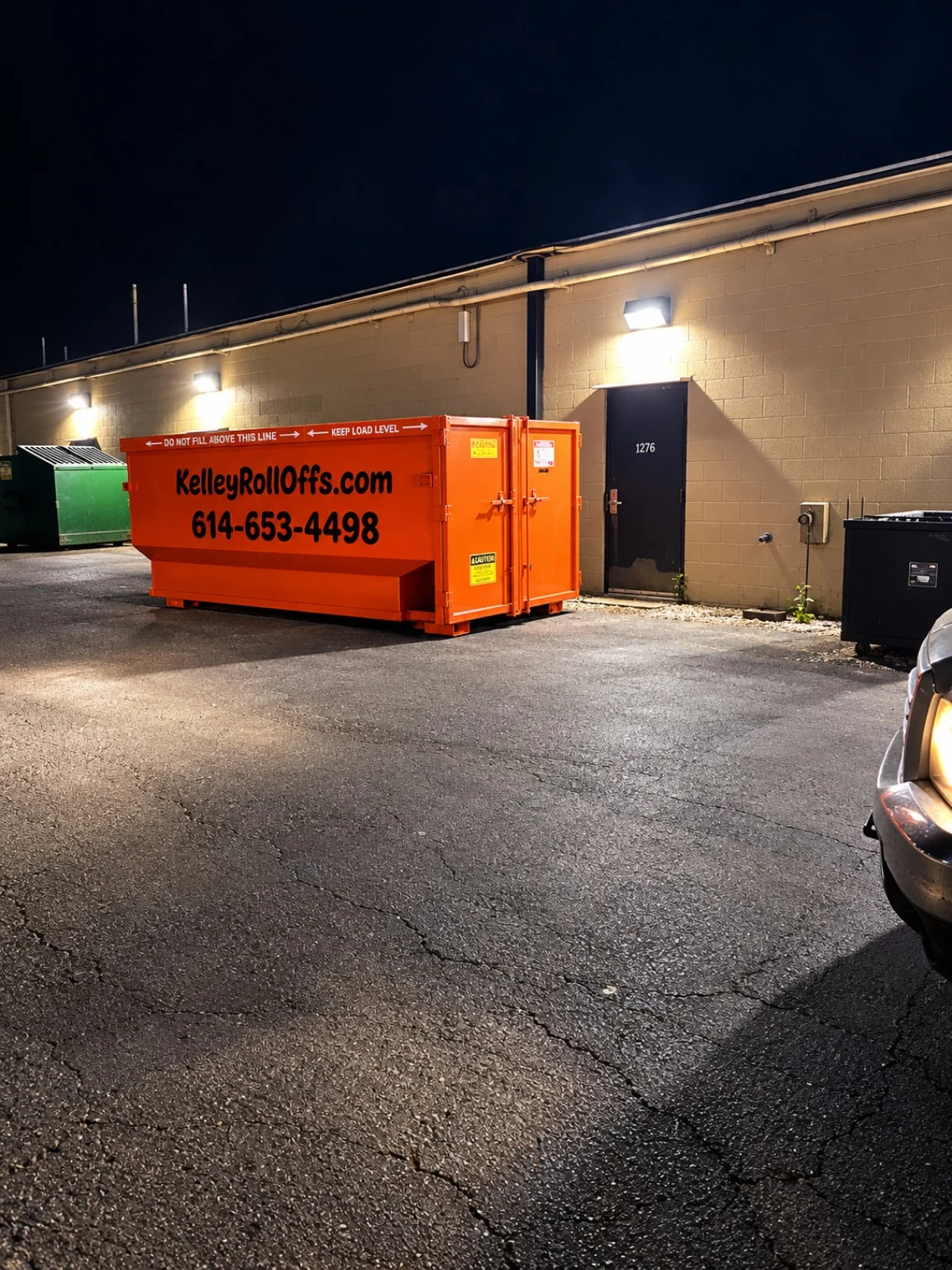 Orange Kelley Roll Offs dumpster at a customer location